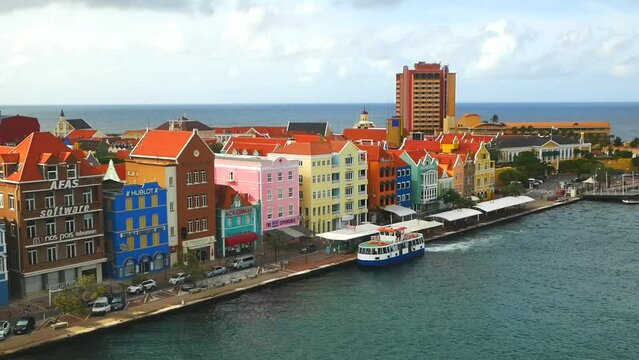 Willemstad, Curacao - 04.28.2021 View of colorful colonial buildings in the old historical city center of the town Willemstad and ferry waiting for tourists in canal 