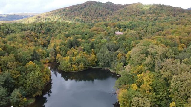 Aerial drone footage of the beautiful nature with a lake and forested mountains in Sovata, Romania