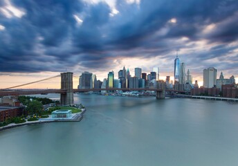 Fototapeta na wymiar Beautiful cloudy sky over the Brooklyn bridge with a city view behind
