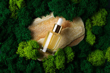Cosmetic mock up with stone and moss, beauty concept with serum bottle