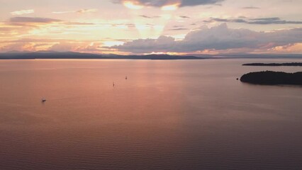 Aerial view of a sunset over waves and sailing boats on lake Champlain, Vermont shot in slow motion