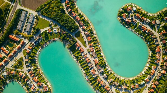Drone view of water bodies surrounded by greenery and buildings in Oberwaltersdorf, Austria
