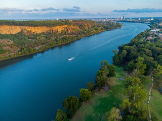 Aerial of a boat sailing in the peacful water of a river surrounded by vegetation
