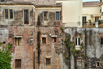 Destroyed walls with windows of townhouses in the city of Catania on the island of Sicily