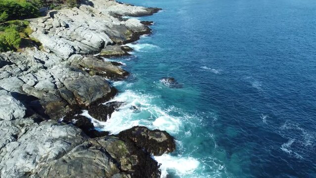 Aerial of waves hitting rocks on Zapallar beach in Chile.