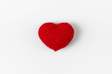 Crocheted red heart on a gray background. Symbol of love. Top view, flat lay