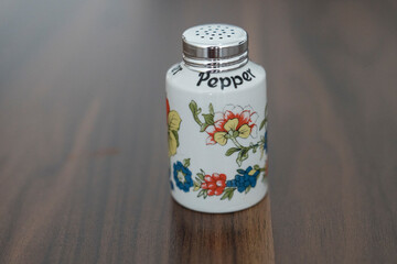 floral-patterned ceramic saltcellar, brown background