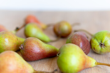 pear on a wooden table close-up in the foreground with a blurred background.	
