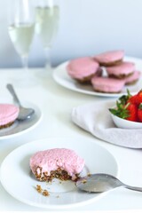Fototapeta na wymiar Closeup vertical shot of a strawberry cheesecake with strawberries and champagne in the back
