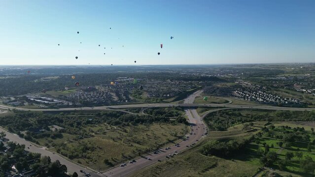 Aerial footage over the city of Olympic with hot air balloons in the air, Colorado Springs