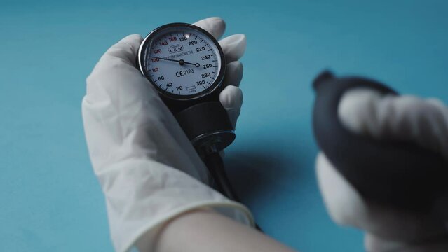 Closeup of a gloved hand checking blood pressure using an old blood pressure monitor