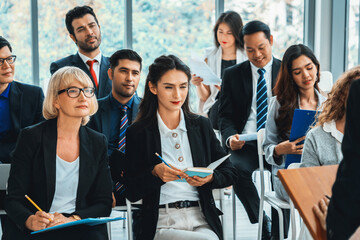 Group of business people meeting in a seminar conference . Audience listening to instructor in employee education training session . Office worker community summit forum with expert speaker . Jivy