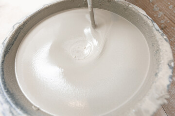 Closeup prepare cement for floor during renovation works, worker use handheld mixer