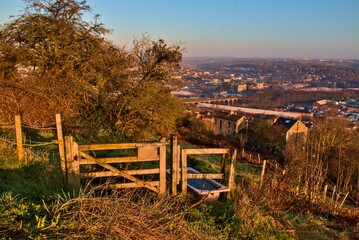 Old wooden fence and the town of Batley in West Yorkshire under the blue sky