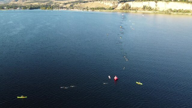 Drone shot of people swimming in the sea and boats in the Penticton Iron Man 2022 swimming event