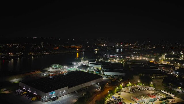 Time lapse drone shot over a city along river at night with lights
