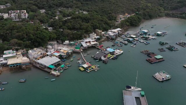 Drone view over a dock with boats and industrial buildings in Sai Kung Island