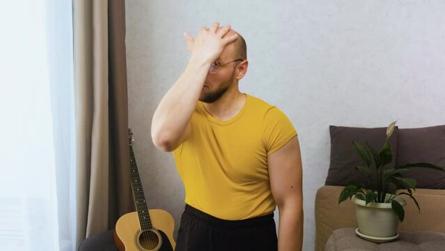 Bald inept seducer nerd moves his eyebrows, preens, flirts and points his finger, looking at the camera