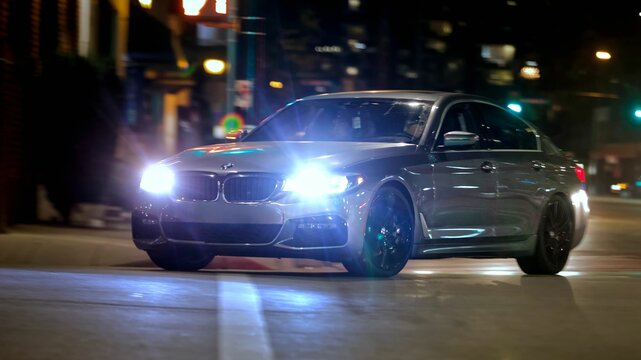 Gray BMW M5 car driving at high speed on the road in the evening