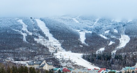 Drone shot of snow covering forests and mountains of Mont-Tremblant city in Quebec, Canada