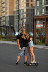 Full length portrait of a happy couple enjoying spending time together skateboarding at sunset.