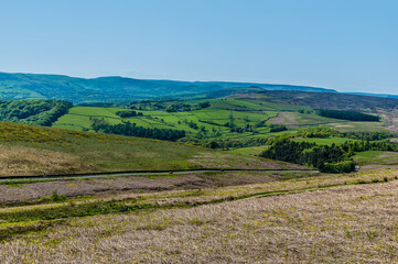 Fototapeta na wymiar A view from the path leading down from the Stanage Edge escarpment across the valley below in the Peak District, UK in summertime