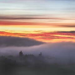 Gorgeous foggy sunrise at Carn Brea Castle in Cornwall with thick clouds going over the keep
