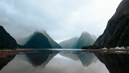 Scenic view of mountains reflecting on a lake on a foggy day