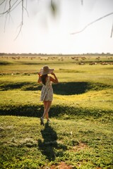 Back view of a young woman standing in the meadows