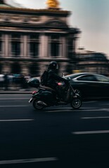 A scooter panning driving during rainy day in Paris, France