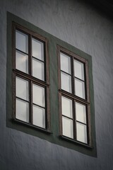 Low angle shot of an old green wooden window on a gray building