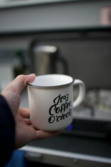 Vertical shot of a hand holding a cup of coffee