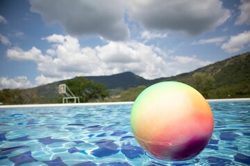 Fototapeta na wymiar Closeup shot of a colorful pool ball on the water on a sunny day