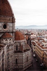 Vertical drone shot of Cathedral Santa Maria del Fiore with a cityscape view on a gloomy day