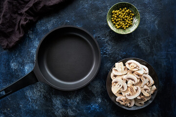 Top view empty dark frying pan with non-stick coating on dark blue abstract background.