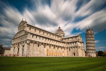 Scenic view of a Pisa Cathedral and Pisa tower under the beautiful sky - obrazy, fototapety, plakaty