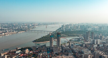 Aerial view of a modern city with at the river shore with a bridge on a bright sunny day