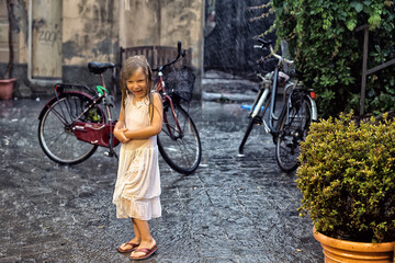Girl in white dress under rain in summer
