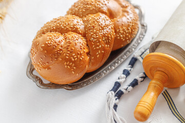 Torah scroll, prayer shawl tallit, kippah and bread. Concept of Jewish holidays Shavuot