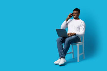 Young black guy businessman using phone and laptop