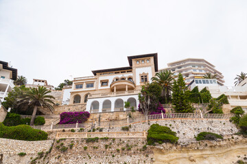 Obraz premium Large, bright, medieval house decorated with palm trees, shrubs and flowers.