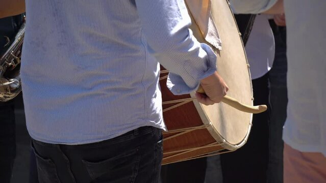 Man drumming on Macedonian wedding ceremony, playing traditional songs with a drum on Balkan wedding