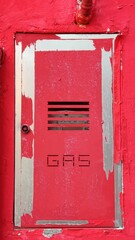 Red metal door with 'gas' text