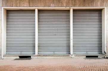 Closeup of three old metal shatters of an entrance on the streets