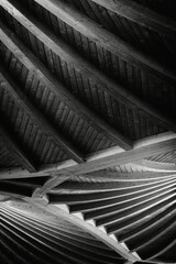 Vertical grayscale shot of abstract structure of a ceiling.