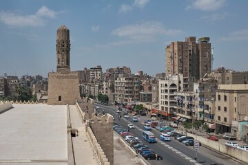 Al-Hakim Mosque in Cairo, Egypt with cars driving on the road on a sunny day