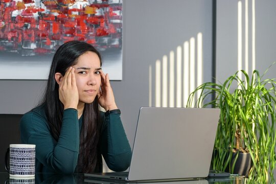 South Asian Woman Having A Business Call At A Desk, Working On A Laptop In Home Office