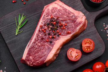 Fresh juicy raw new york beef steak with salt, spices and herbs