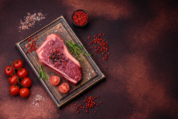 Fresh juicy raw new york beef steak with salt, spices and herbs