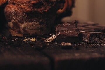 Chocolate pastries on a table, with crumbs and broken pieces scattered around the surface